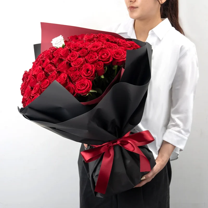 パティスリーフラワーのバラの花束100～108本を持つ女性