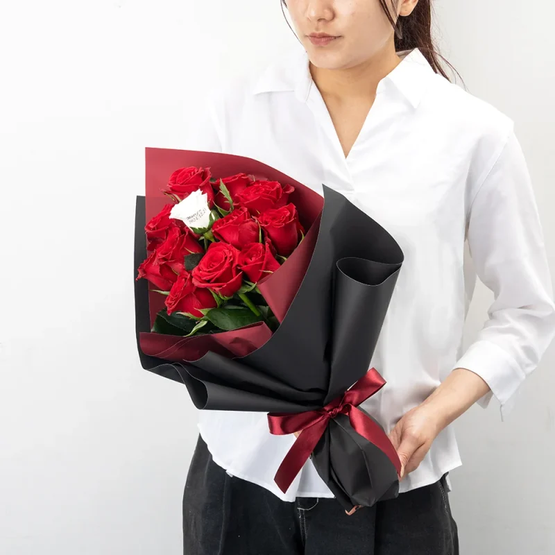 パティスリーフラワーのバラの花束12本を持つ女性