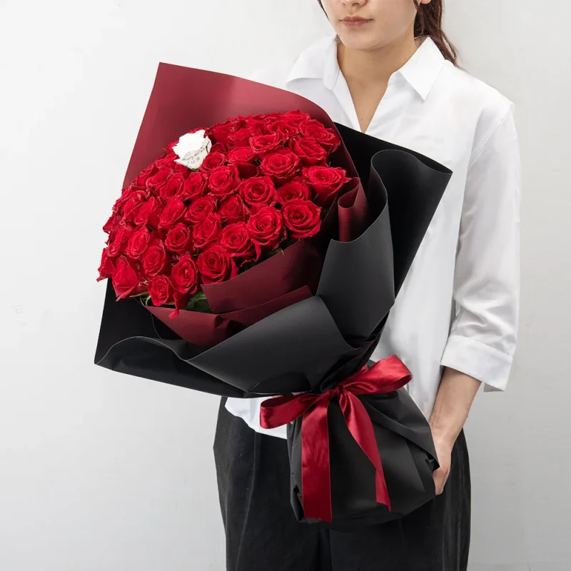 パティスリーフラワーのバラの花束50～60本を持つ女性